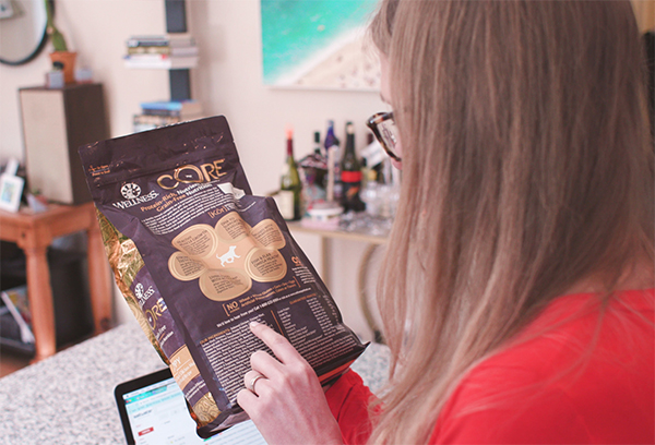 woman looking at dog food ingredients