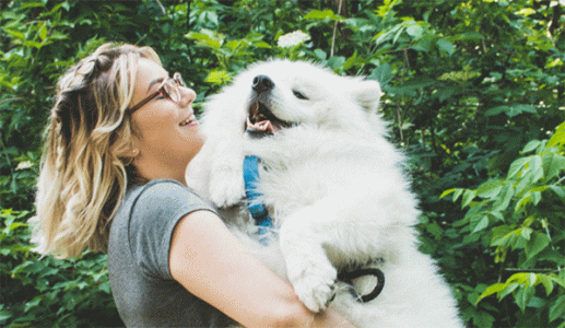 person snuggling dog outside 